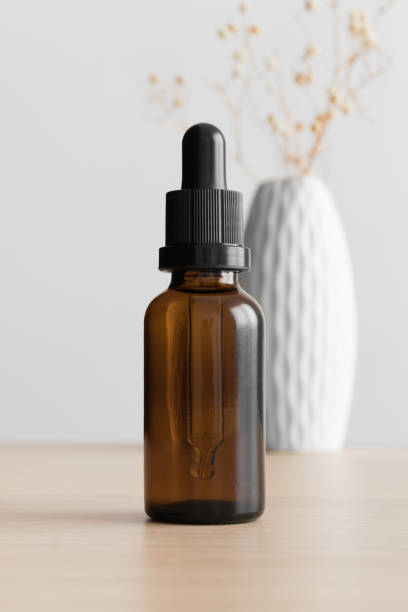 istock Dropper bottle mockup with a gypsophila on the wooden table. 1368024893
