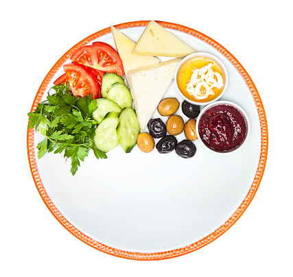 Healthy breakfast. Traditional turkish green and black olives, cheese, tomatoes, cucumber, parsley,raspberry jam, honey on white plate isolated on white background (with clipping path)