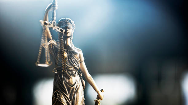 istock Blindfolded lady justice is holding scales 1368030381