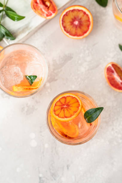 istock Cold refreshing drink with tonic, blood Sicilian oranges and ice, grey background. Cocktail with tonic and oranges. 1368030756
