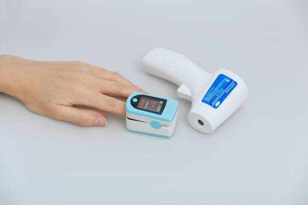 istock Pulse oximeter and thermometer gun on white background. Measuring oxygen saturation, pulse rate and oxygen levels. Infrared isometric thermometer gun to check body temperature for virus symptoms 1368033342