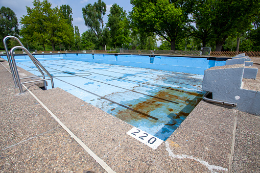 Drained swimming pool. Cleaning equipment, preparing for the summer season