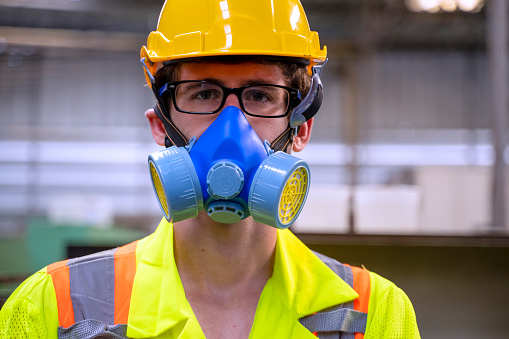 Blue collar worker at factory. He is wearing safety suit.