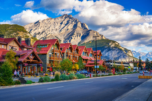 Banff, Alberta, Canada - September 26, 2021 : Scenic street view of the Banff Avenue with cars and tourists. Banff is a resort town and popular tourist destination.