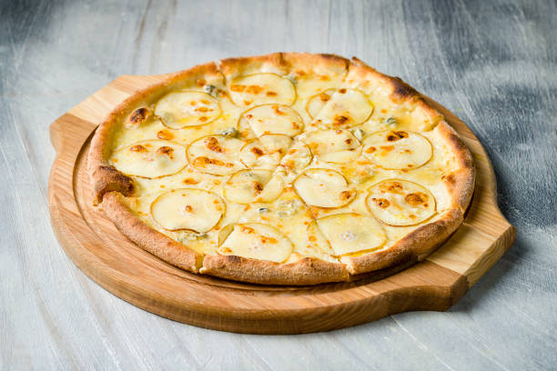 istock Pizza with pears and Gorgonzola cheese on wooden board on grey table 1368036964