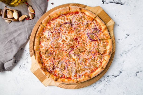 istock Pizza with tuna and red onion on the board on grey table top view 1368037302