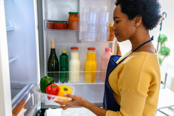 istock Woman looking at food in refrigerator 1368038201