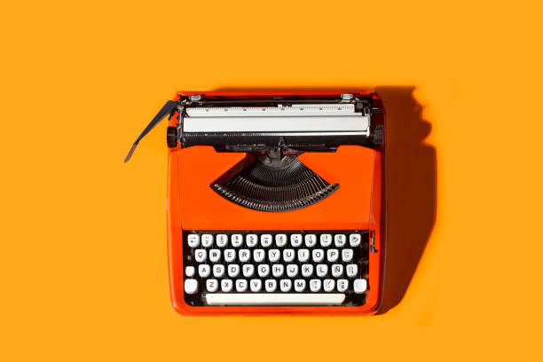 istock An orange vintage typewriter on an orange background in a top view 1368039465