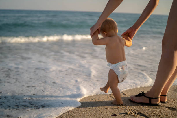 первые шаги на морском пляже - young family family with one child walking learning стоковые фото и изображения