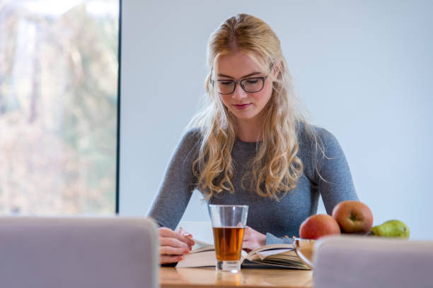 istock Girl drinking hot tea and reading book 1368040827