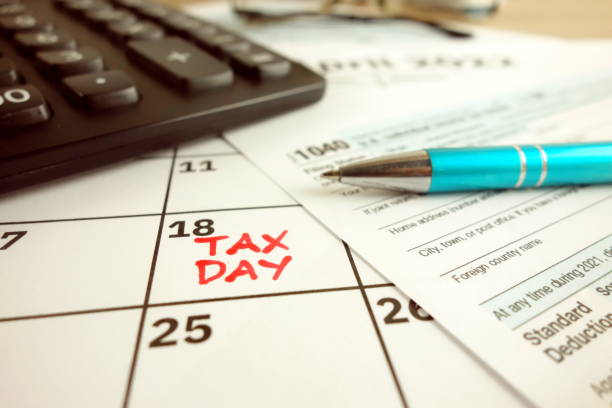 día de pago de impuestos marcado en un calendario - 18 de abril de 2022 con el formulario 1040 - 18 fotografías e imágenes de stock