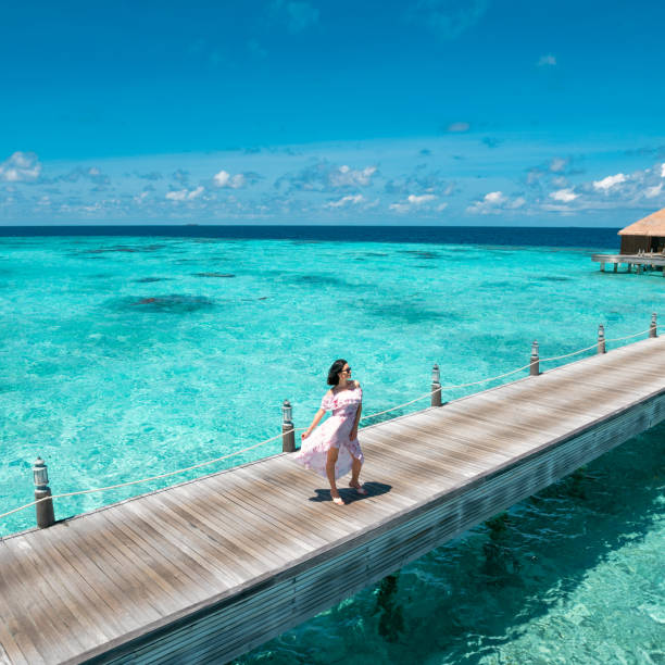 istock Beautiful woman enjoying view on jetty bridge 1368042881