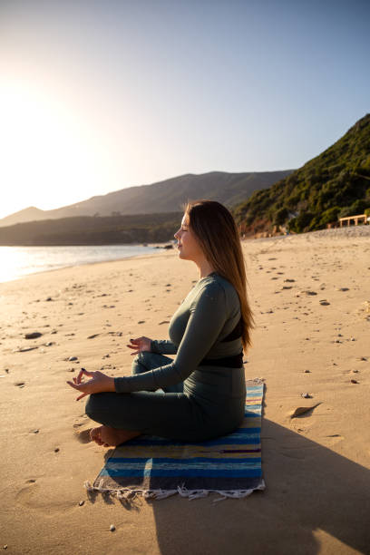 istock Woman enjoying the sun at the beach 1368044014