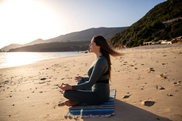 istock Woman enjoying the sun at the beach 1368044021