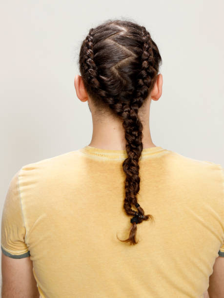 istock Stylish male model with braids posing in studio on isolated background. 1368046373