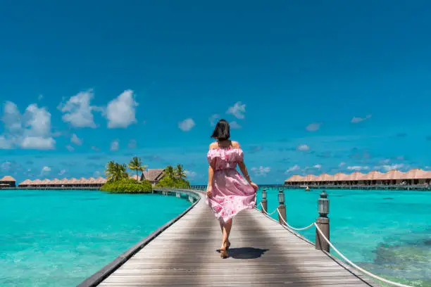 Photo of Beautiful woman walking on jetty bridge in Maldives