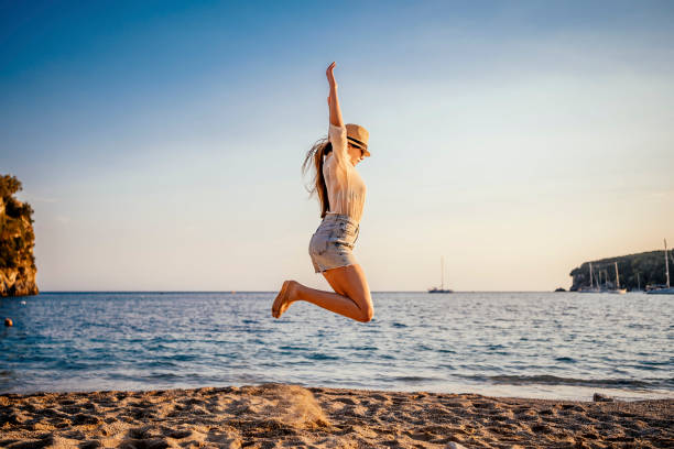 istock Woman jumping on the beach 1368048964