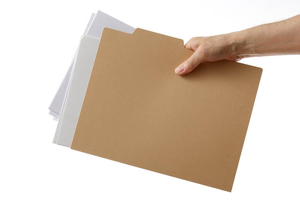 Isolated shot of holding a file folder against white background Close-up shot of holding a brown file folder with documents against white background.  file folder stock pictures, royalty-free photos & images