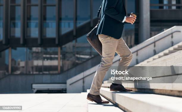 Shot Of A Businessman Walking Up A Flight Of Stairs Against An Urban Background Stock Photo - Download Image Now