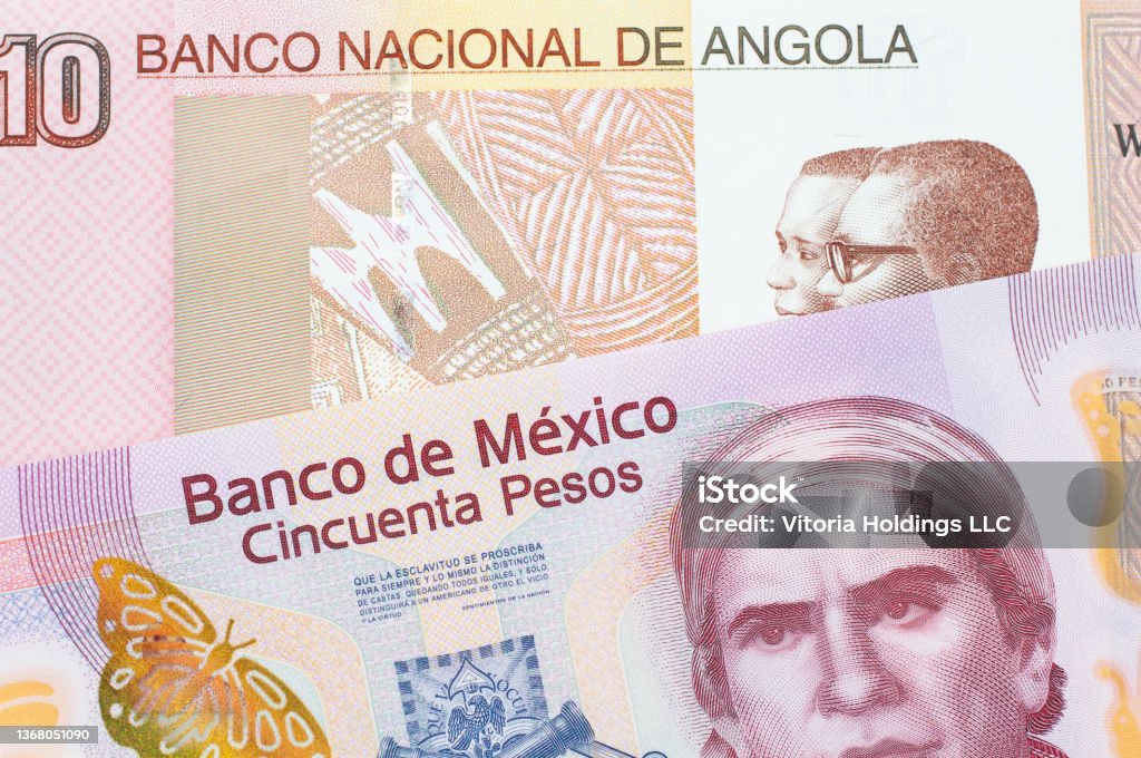 A pink, plastic fifty peso bank note from Mexico paired with a colorful ten kwanza bank note from Angola. A macro image of a pink, plastic fifty peso bank note from Mexico paired up with a colorful ten kwanza bank note from Angola.  Shot close up in macro. Angolan Kwanza Stock Photo
