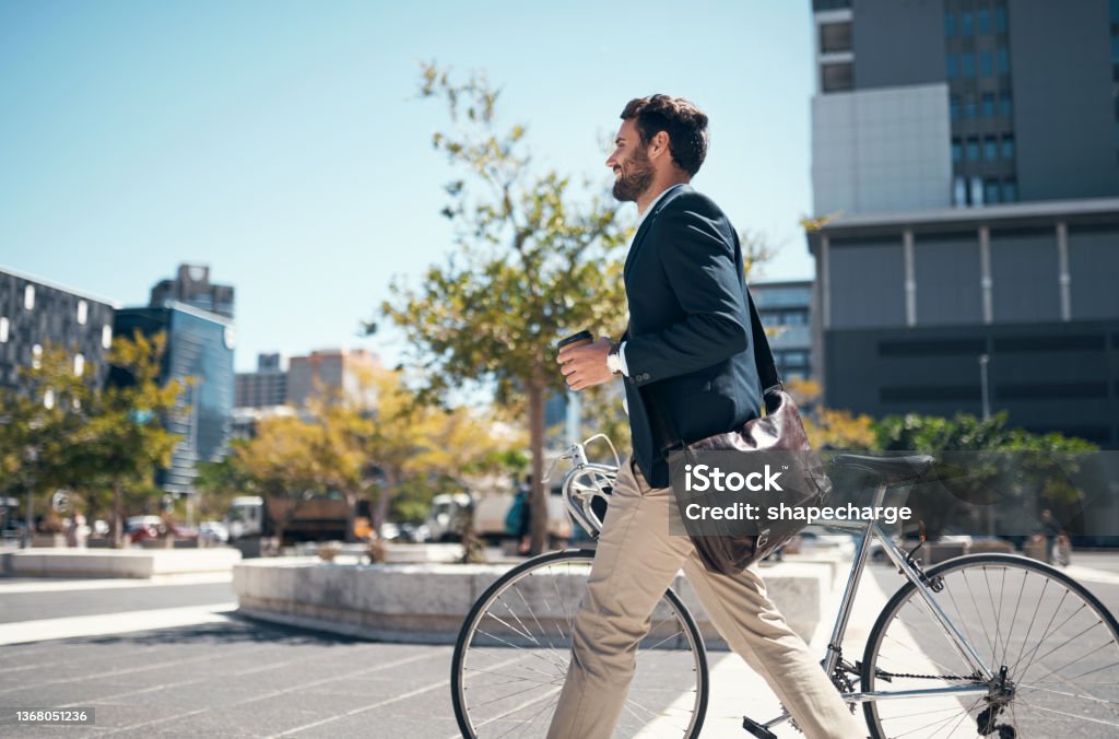 Shot of a young businessman traveling through the city with his bicycle Give me wheels and I'm good to go Cycling Stock Photo