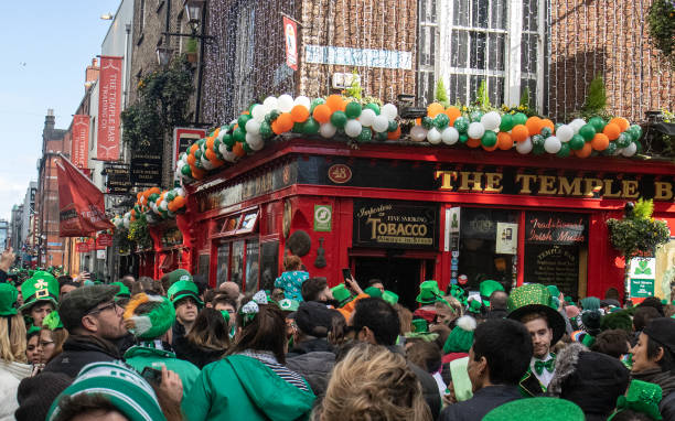 Dublin, Ireland - MAR 17: St. Patrick's Day, people with green hats and irish flags in Dublin city on March 17, 2019 in New Dublin, Ireland.
