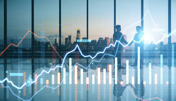 istock Businessmen shaking hands in modern bright office interior with glowing forex chart, panoramic windows with city view and reflections on floor. Teamwork, cooperation, trade, finance and success concept. Double exposure. 1368054045