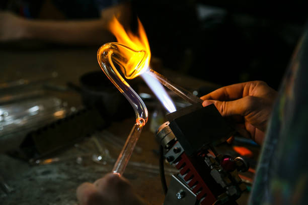Process of handmade glassworks manufacturing with glass blowing burner Process glass blowing manufacturing . Fire heats glass blank with glass-blowing burner. Handmade glassworks hand blown glass stock pictures, royalty-free photos & images
