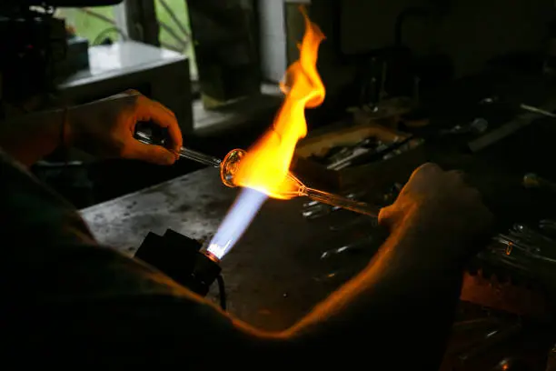 Process glass blowing manufacturing . Fire heats glass blank with glass-blowing burner. Handmade glassworks
