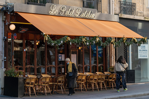 Paris, France - January 11 2022: Empty outdoor terrace of Parisian cafe Le Petit Lutetia in Paris city centre on a cloudy winter day.