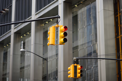 Yellow Traffic Light on background of skyscrapers, Manhattan, New York, USA. Red stop signal. Yellow Traffic Light is one of a characteristic feature of nyc.