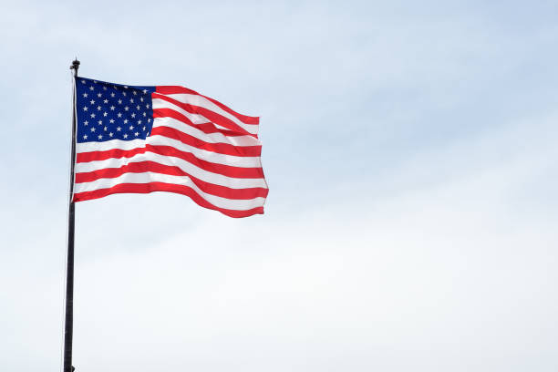 istock USA flag on blue sky. The star-spangled American flag. 1368058426