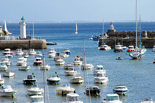 Sauzon harbour entrance and lighthouse, La Belle Ile, Morbihan, France. Sauzon is one of the main ports on the island and a tourist attraction with its beautiful architecture and tidal basin marina that attracts recreational sailors and fishing boats alike