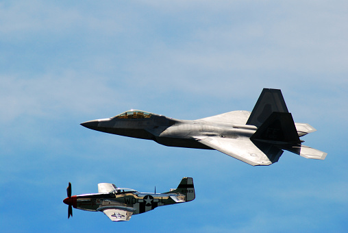 Wantagh, NY, USA May 23 A P 51 Mustang from World War II and a modern F 22 Raptor fly along side each other representing different tines of aviation history