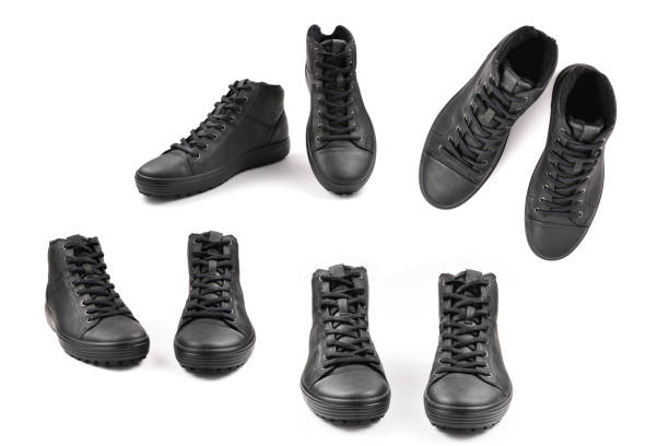 istock men's black leather shoes and a black camera on a black background. Copy space. 1368059969