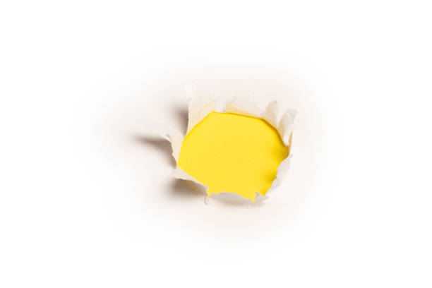 istock A hole in a white paper on a yellow background. 1368059991