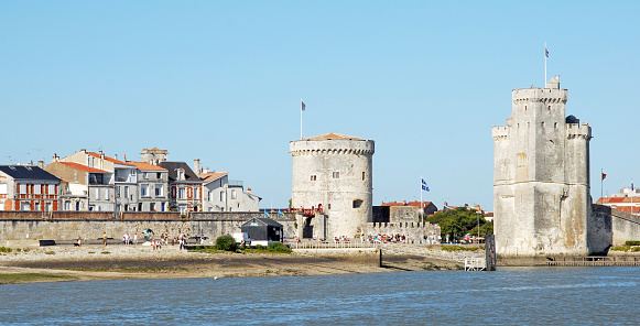 Sea approach to the fortified towers guarding the entrance of La Rochelle harbour, Charente Maritime, France. La Rochelle is an ancient medieval coastal town on the Bay of Biscay Atlantic coastline full of Renaissance architecture and numerous stone arches that join half timbered houses in the narrow streets and is now the capital of the region