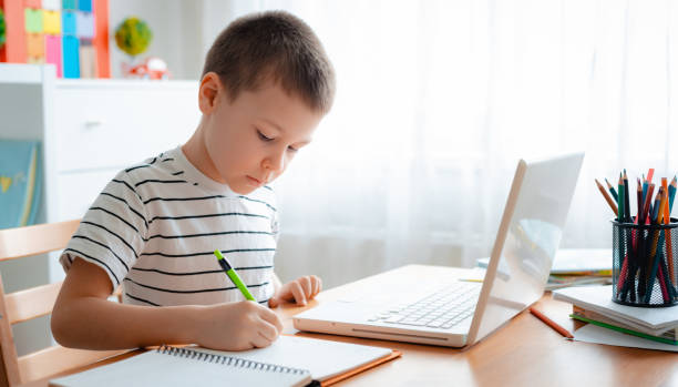 istock Distance learning online education. A schoolboy boy studies at home and does school homework. A home distance learning 1368064126