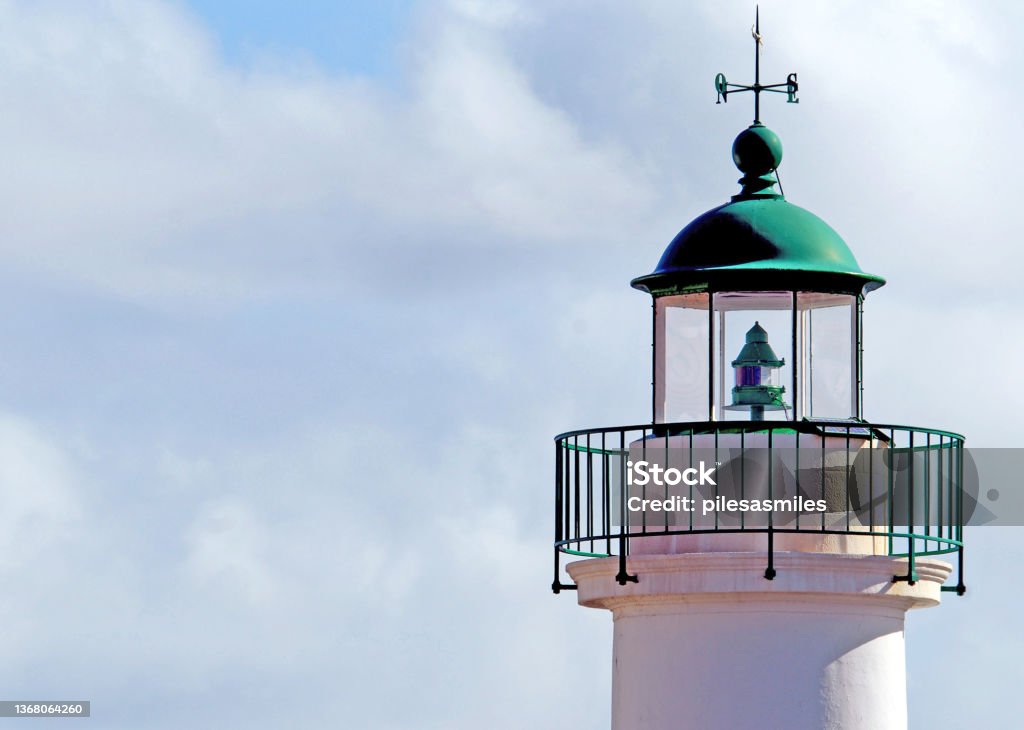 Lighthouse tower top and cloudscape, Sauzon harbour, Belle Ile, France Lighthouse lighting equipment at top of illuminated glass tower as warning to sailors, Sauzon harbour, Belle Ile, Brittany, northwest France Brittany - France Stock Photo