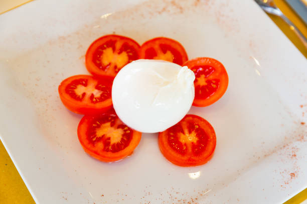 Popular Italian snack Buratta with tomatoes, made from tender cheese and fresh sliced tomatoes