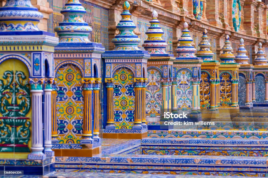 The typical ceramic and colourful benches of the famous Spanish square plaza de Espana) in Seville. The typical ceramic and colourful benches of the famous Spanish square plaza de Espana) in Seville. It is built in 1928 for the Ibero-American Exposition. The benches all represent a region in Spain Seville Stock Photo