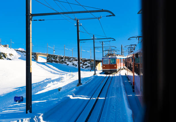 istock Red train running on rack railway through snowy Swiss Alps 1368064383