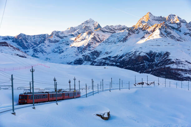 istock Red swiss train running through snow 1368064395