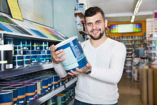 istock Male customer examining various wall paints 1368065660