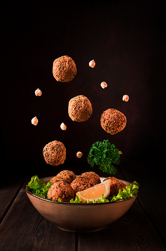 Chickpea falafel balls, on a wooden table, close-up, vegetarian food,levitation, vertical,