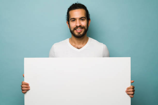 istock Attractive man holding a sign for copy space 1368067349