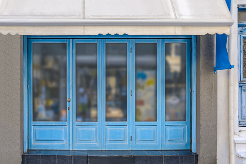 Blue painted wooden facade of a sales room shop