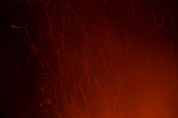 istock Red sparks of fire from a bonfire with a black background 1368071838
