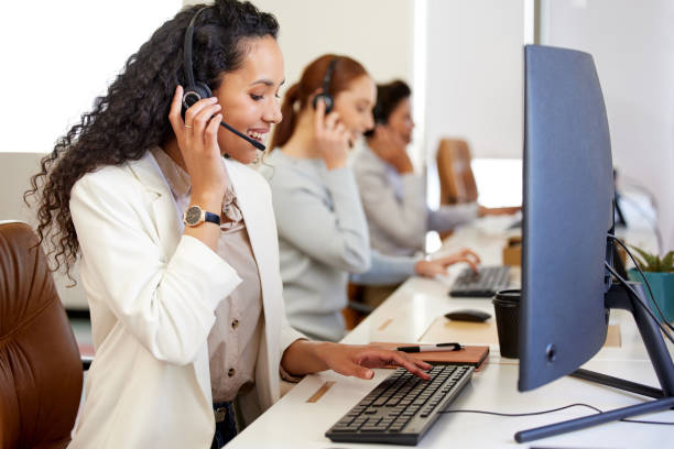 istock Shot of a young call centre agent working on a computer in an office with her colleagues in the background 1368072148