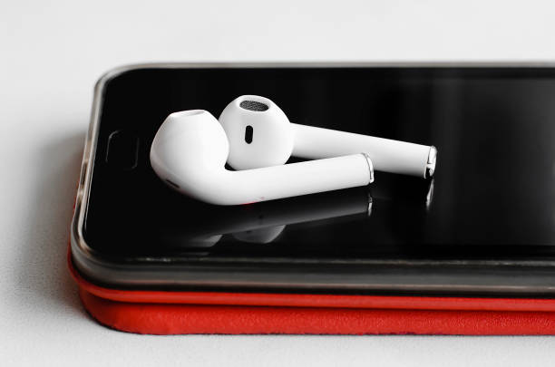 Wireless headphones next to the phone, close-up. Wireless headphones next to the phone, close-up. earbud stock pictures, royalty-free photos & images